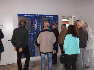Vor Musterwand mit Modellen die bereits gefertigt wurden